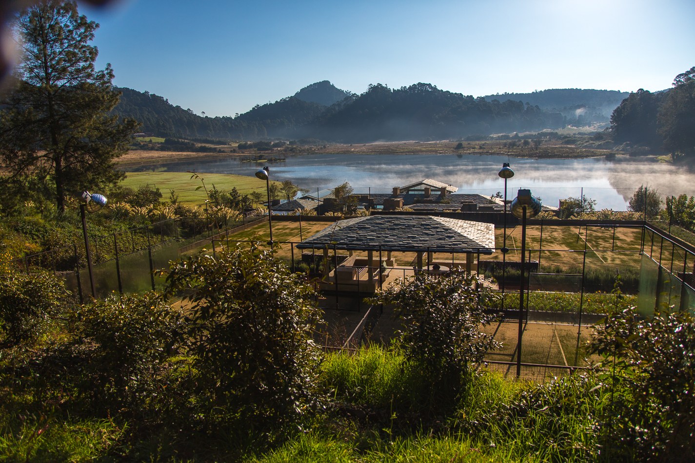 Pergola fotovoltaica integrada al paisaje con lago y montañas al fondo